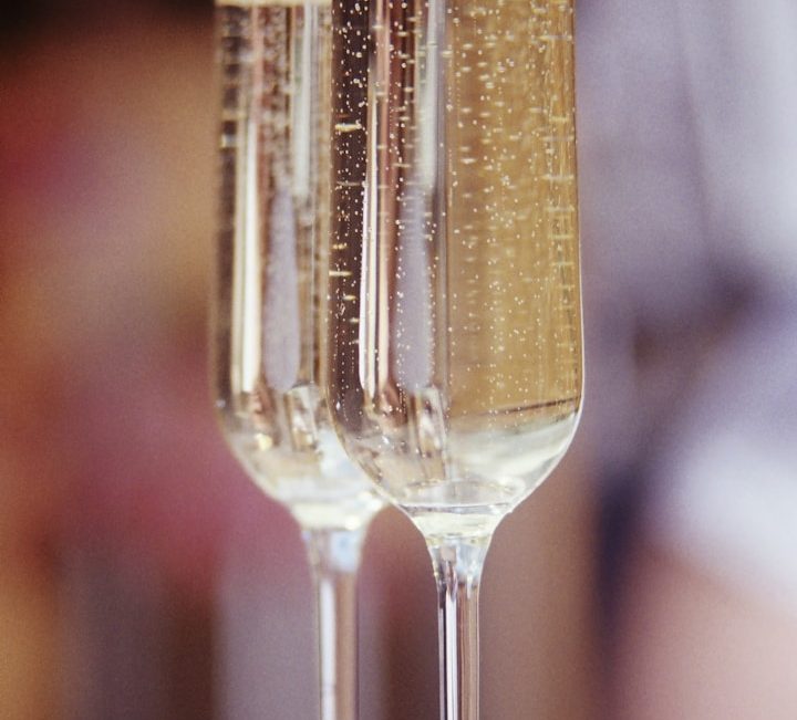 Two flutes filled with sparkling champagne against a blurred background.