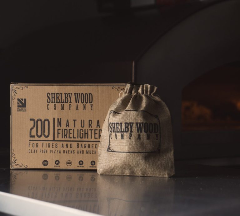 Brown hessian sack for natural firelighters beside a box labelled with product details.